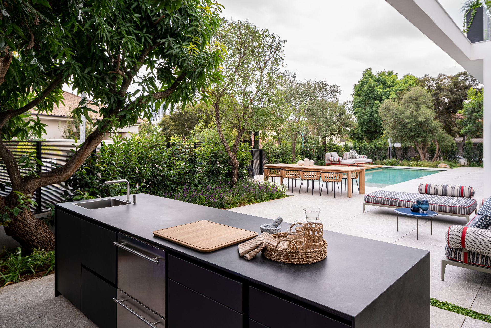 Black UNICA island with drawers open beside a pool