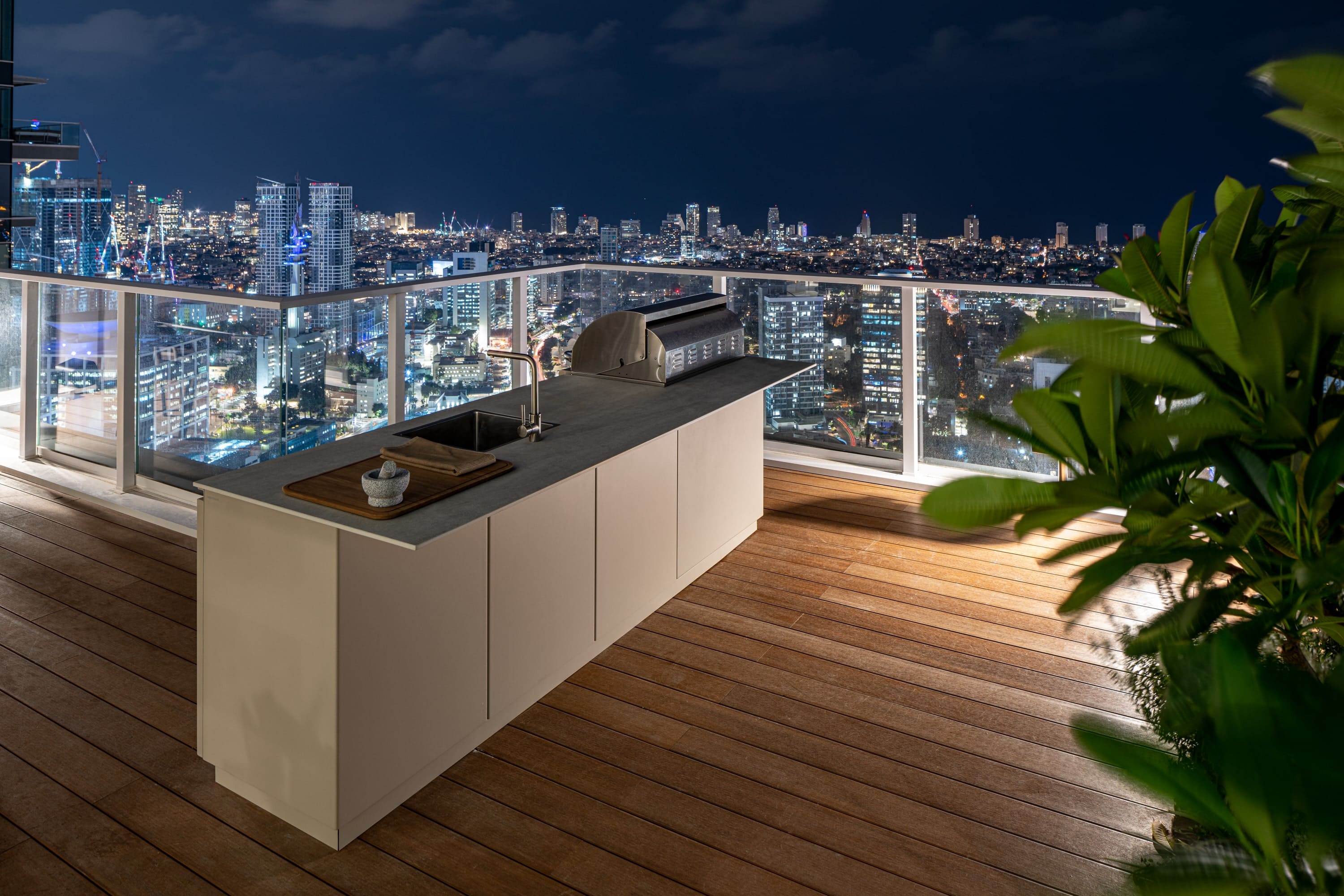 UNICA rooftop kitchen at night with city lights