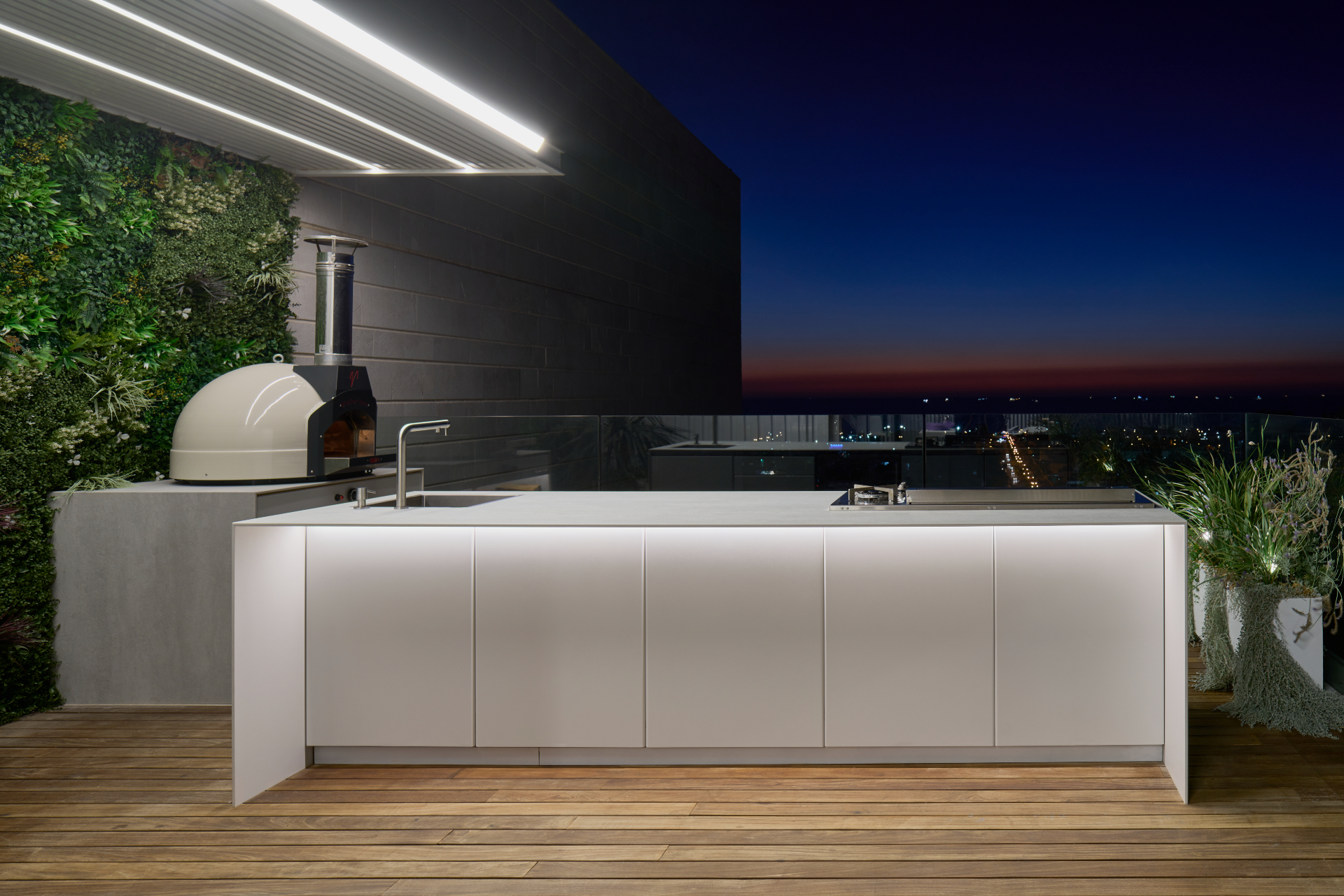 White UNICA island at dusk with pizza oven